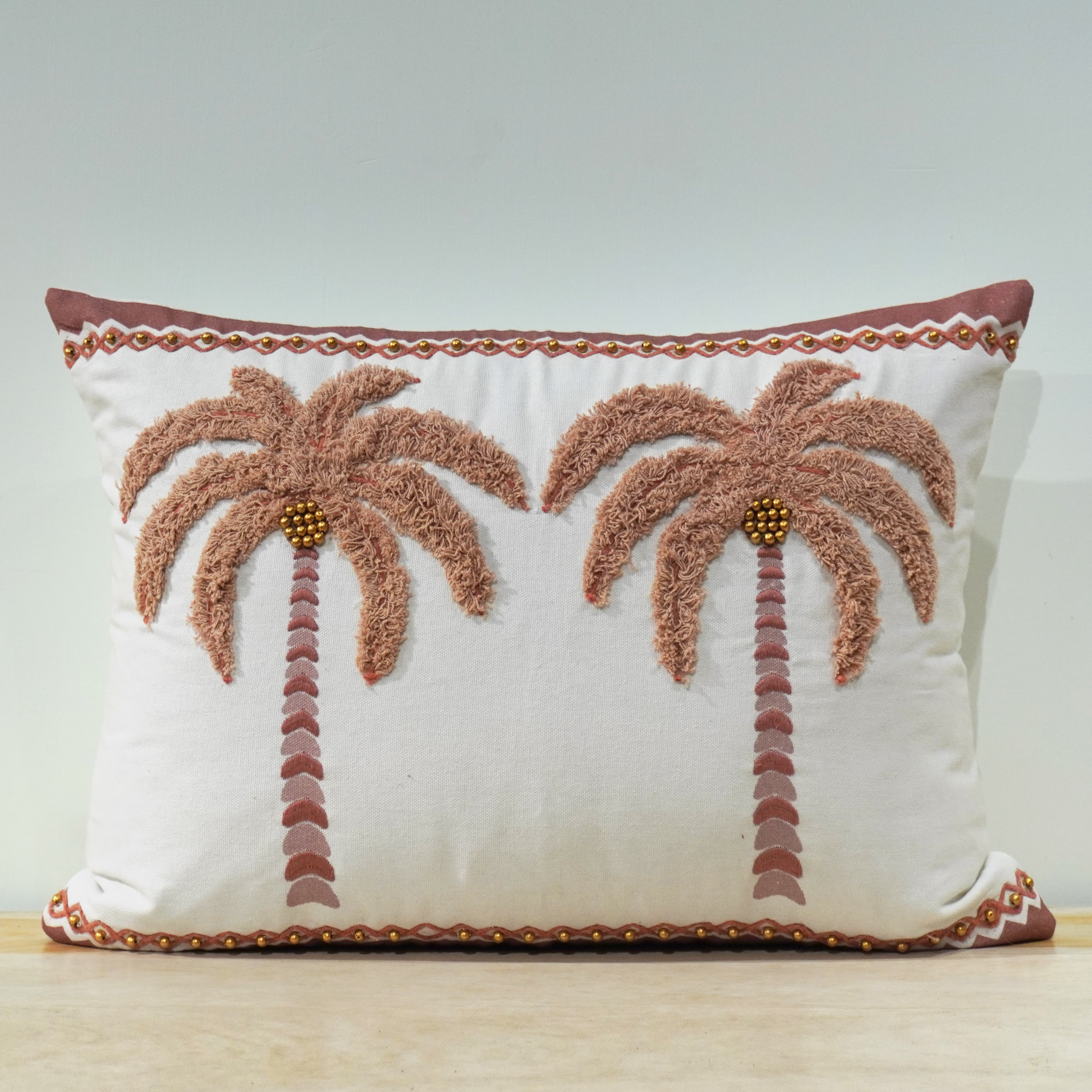Palm tree tufted lumbar cushion in dusty rose chenille with gold bead accents