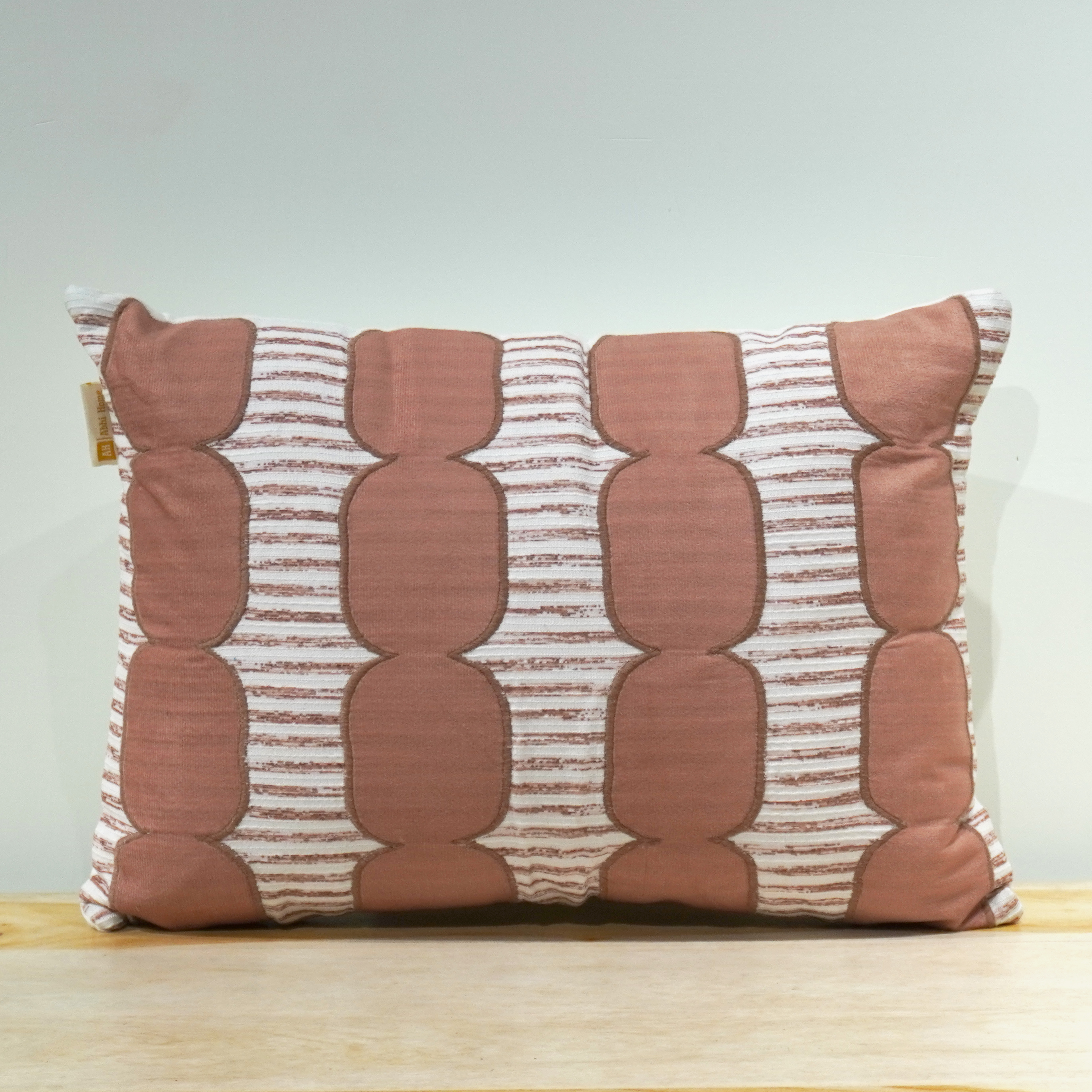 Geometric oval appliqué lumbar cushion in terracotta on striped woven base