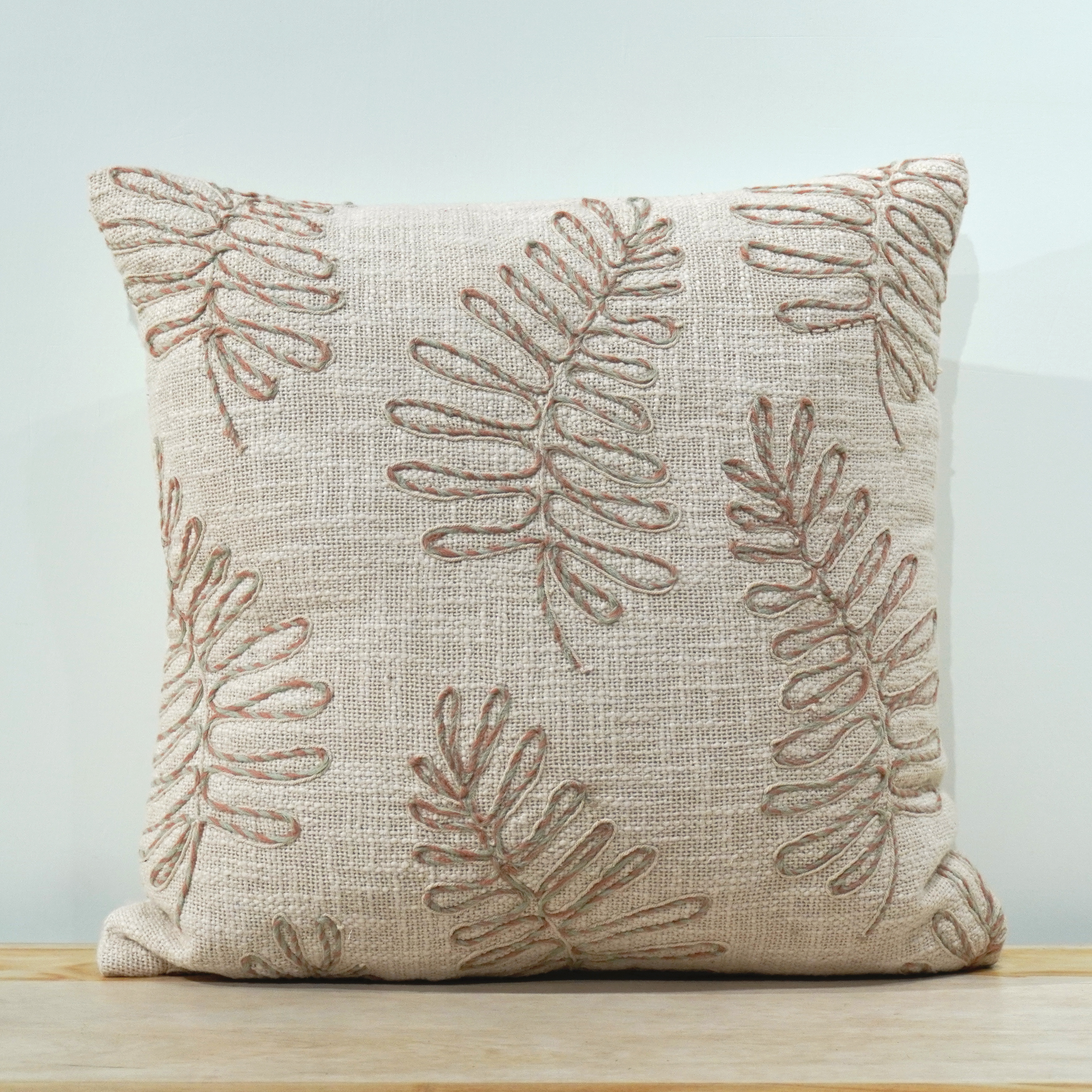 Natural linen square cushion with scattered fern embroidery in dusty rose