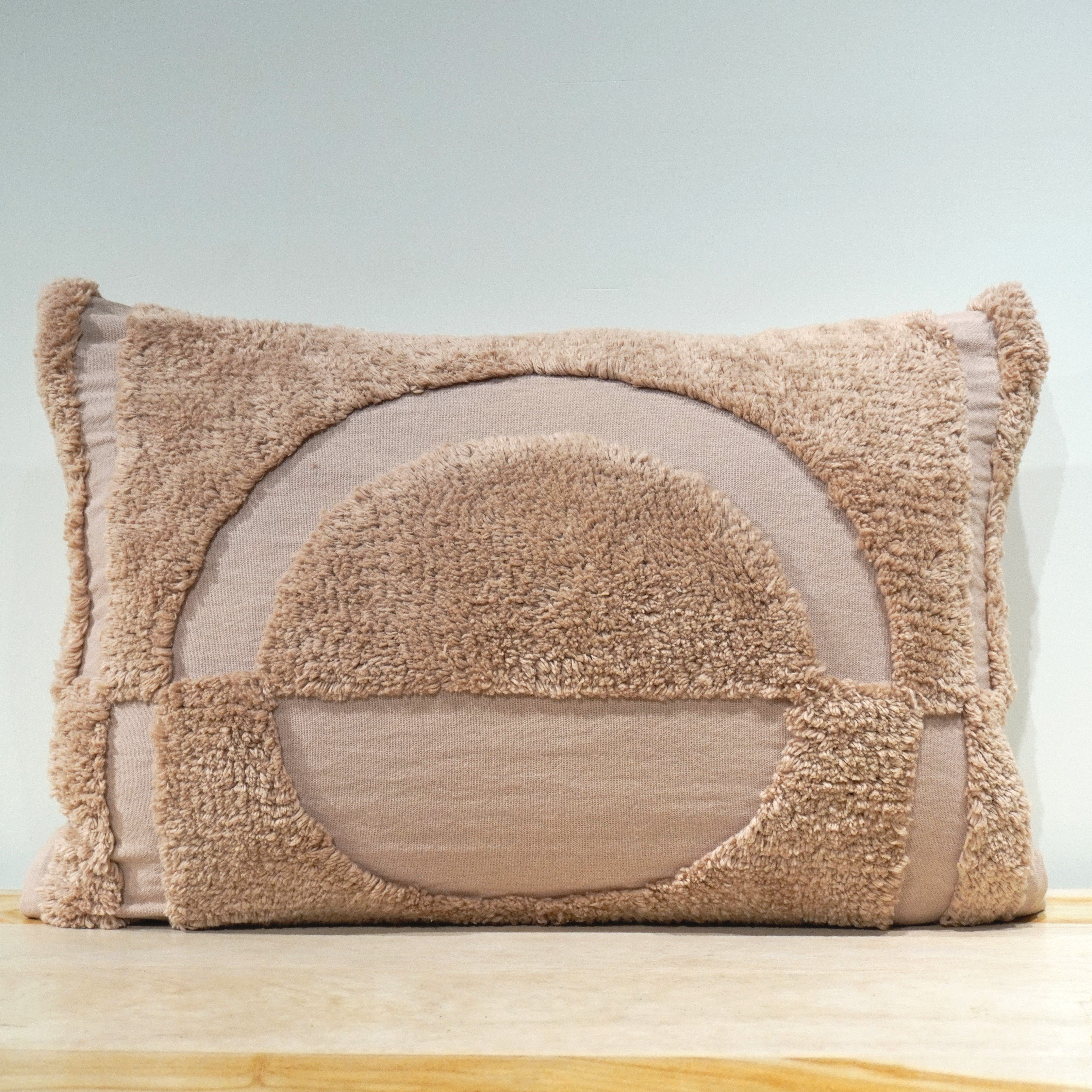 Taupe blush lumbar cushion with raised semicircle rising sun tufted pattern