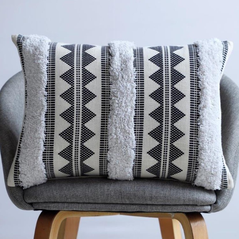 Ivory lumbar cushion with black aztec tribal zigzag print and white tufted stripe inserts
